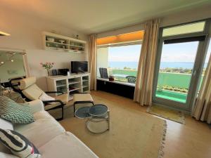 a living room with a couch and a large window at Panoramic App A09-5 in Sierksdorf