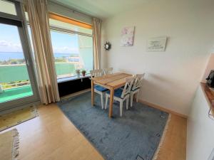 a dining room with a table and chairs and a window at Panoramic App A09-5 in Sierksdorf