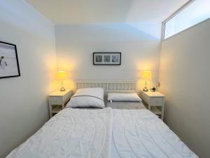 a bedroom with a large bed and two lamps at Panoramic App A09-5 in Sierksdorf +14 photos