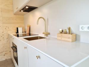 een keuken met witte werkbladen en een wastafel bij Vakantiewoning Studio 51 OK49 in Oostkapelle +20 foto's
