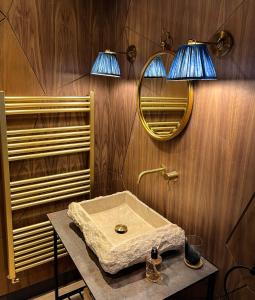 een badkamer met een wastafel en 2 lampen aan de muur bij The Garden Rooms in Chathill