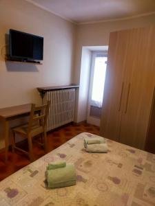 een slaapkamer met een bed met twee groene handdoeken erop bij Locanda Da Tullio in Capovalle