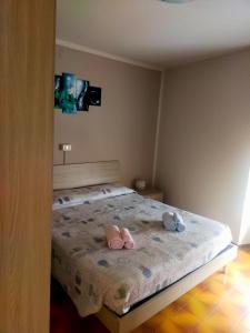 - une chambre dotée d'un lit avec deux chaussures roses dans l'établissement Locanda Da Tullio, à Capovalle