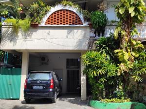 a car parked in front of a house at Beach House Apartment in Legian
