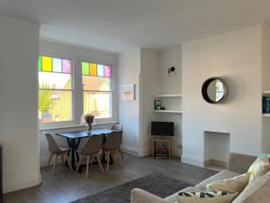 a living room with a table and chairs at Bright and Stylish 2 Bedroom First Floor Flat in London