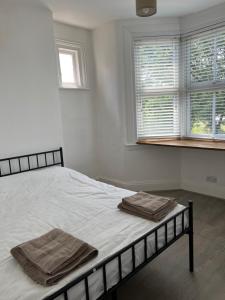 a bedroom with a bed with two towels on it at Bright and Stylish 2 Bedroom First Floor Flat in London