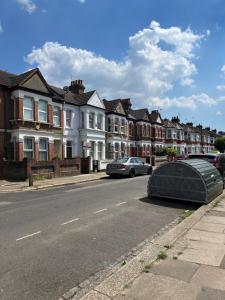 um carro estacionado ao lado de uma rua com casas em Bright and Stylish 2 Bedroom First Floor Flat em Londres