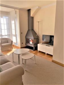 a living room with a couch and a fireplace at Apartamentos Del Pisuerga in Cervera de Pisuerga