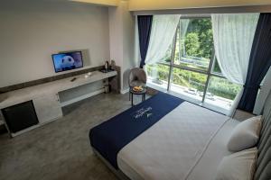 a hotel room with a bed and a tv and window at Newarise Hotel in Rize