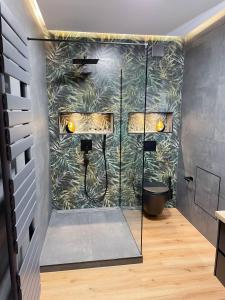 uma casa de banho com um chuveiro e uma parede verde em Appartement am Mythenweg em Thale