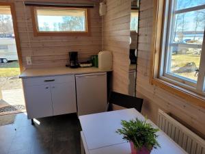 a kitchen in a tiny house with a table and a window at Tydingesjöns Camping & Festplats in Broby