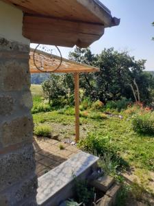 a wooden pergola with a bench in a yard at Casale Gatta Morena in Pianiano