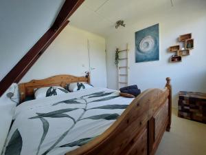 een slaapkamer met een groot houten bed in een kamer bij Marretoer in Uitwellingerga