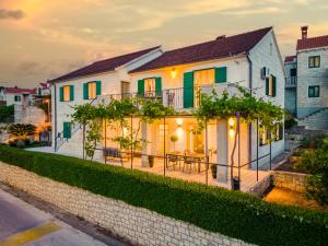 a white house with a fence in front of it at Apartman A`Mare in Postira