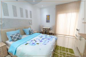 um quarto com uma cama grande e almofadas azuis em Kristal Apartmani - Banja Ždrelo em Zdrelo