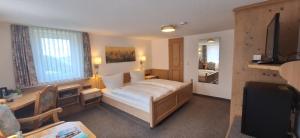 a bedroom with a bed and a desk and a mirror at Landhaus Gnacke in Schmallenberg