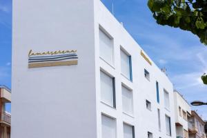 a white building with a sign on the side of it at Hostal Boutique La Mar Serena in Peñíscola