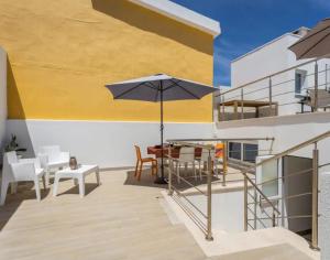 a patio with an umbrella and a table and chairs at Casa da Madou in Setúbal