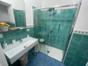 y baño con ducha acristalada y lavamanos. en Hotel Villa Cerelis, en Diamante