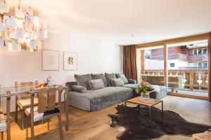 a living room with a couch and a table at Firefly Luxury Suites in Zermatt