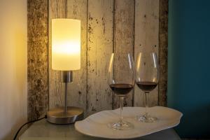 two glasses of wine on a table with a lamp at 3 Sirene Sciacca Fronte Mare in Sciacca