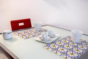 a table with two plates and cups and a red box at 3 Sirene Sciacca Fronte Mare in Sciacca