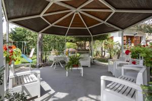 a patio with white chairs and a large umbrella at 3 Sirene Sciacca Fronte Mare in Sciacca