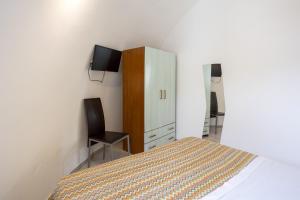 a bedroom with a bed and a cabinet and a chair at 3 Sirene Sciacca Fronte Mare in Sciacca