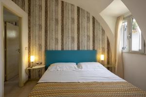 a bedroom with a large bed with a blue headboard at 3 Sirene Sciacca Fronte Mare in Sciacca