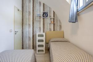 a bedroom with two beds and a dresser at 3 Sirene Sciacca Fronte Mare in Sciacca