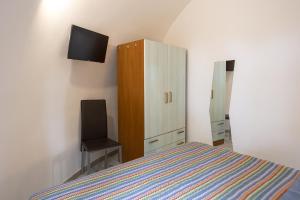 a bedroom with a bed and a cabinet and a television at 3 Sirene Sciacca Fronte Mare in Sciacca