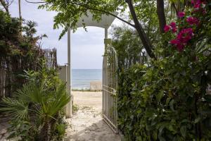 an open gate leading to the beach with flowers at 3 Sirene Sciacca Fronte Mare in Sciacca