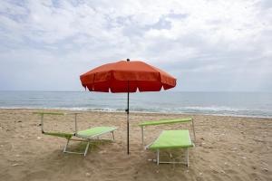 two chairs and an umbrella on the beach at 3 Sirene Sciacca Fronte Mare in Sciacca