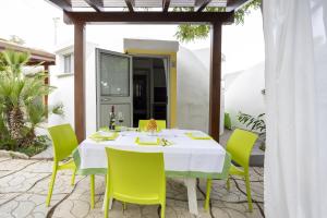 a white table with green chairs on a patio at 3 Sirene Sciacca Fronte Mare in Sciacca