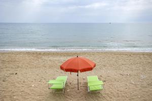 two chairs and an umbrella on the beach at 3 Sirene Sciacca Fronte Mare in Sciacca