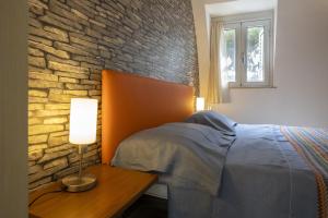 a bedroom with a bed and a brick wall at 3 Sirene Sciacca Fronte Mare in Sciacca