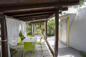 a patio with a white table and green chairs at 3 Sirene Sciacca Fronte Mare in Sciacca