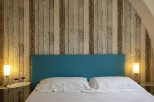 a bed with a blue headboard in a bedroom at 3 Sirene Sciacca Fronte Mare in Sciacca