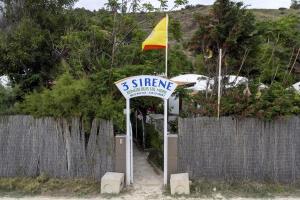 a sign in front of a fence with a yellow flag at 3 Sirene Sciacca Fronte Mare in Sciacca