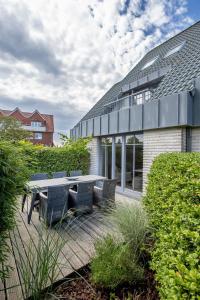 a patio with a table and chairs in front of a building at Ferienhaus Seeschwalbe 12 2 in Langeoog
