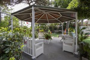 a pavilion with a table and chairs under it at 3 Sirene Sciacca Fronte Mare in Sciacca