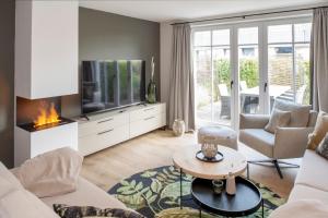 uma sala de estar com um sofá e uma televisão em Ferienhaus Seeschwalbe 12 2 em Langeoog