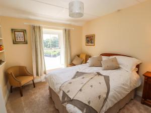 a bedroom with a large bed and a window at Rose Cottage in Settle