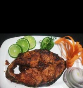 un plato de comida con un trozo de carne y hortalizas en Coco Beach Gokarna en Gokarna