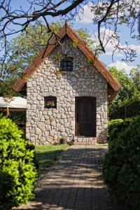 - un bâtiment en pierre avec une porte et une passerelle en briques dans l'établissement Dióliget - Zöld Dió Házikó, à Lovasberény