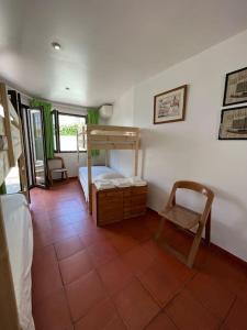 Habitación con 1 dormitorio con litera y silla en Villa típica ideal para as suas férias em família! en Monte Gordo