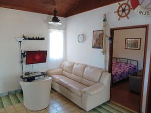 ein Wohnzimmer mit einem Sofa und einem Bett in der Unterkunft CAPTAIN'S Holiday HOUSE in Žirje