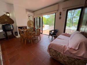 1 dormitorio con 1 cama, mesa y sillas en Villa típica ideal para as suas férias em família! en Monte Gordo
