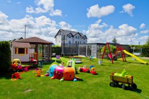 a playground with many different types of play equipment on the grass at Pokoje Gościnne IDALIA - Blisko Plaży Komfort i Wygoda in Karwia