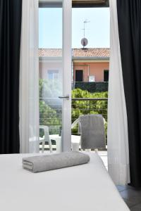 1 dormitorio con cama blanca y ventana en Hotel Eden, en Lido di Jesolo